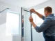 Installing a shower screen door with modern fixtures set in a stylish bathroom.