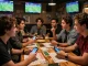Engaged friends analyzing kèo nhà cái 5 at a vibrant sports bar with live broadcasts.