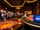 Engaged players at Nhà Cái 68VIP with casino tables and vibrant slot machines.