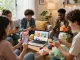 Group of friends exploring custom plushies in a cozy living room.