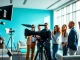 Showcasing corporate video production team collaborating with high-end equipment in a bright setting.