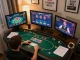 Player strategizing poker gameplay with BL555 on multiple screens in cozy home setup.
