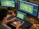 Person engaged in strategic sports betting using laptop, focusing on kèo nhà cái for informed decisions.