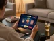 Player engaging with CM88 casino app on tablet in a cozy home setting.