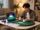 Player enjoying poker on ALO8 app at home with strategy notes and laptop setup.