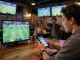 Spectators engaged in sports betting excitement, analyzing soi keo nha cai strategies on their smartphones