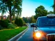 Capture the lively atmosphere of Brooklands with a modern taxi amidst vibrant streets and greenery.