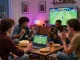 Friends excitedly engaging in online betting on the 399W platform in a cozy living room.