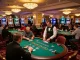 Players strategizing at SC88 blackjack tables in a bustling upscale casino, dynamically engaged in gameplay.